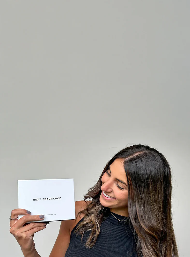 A Next Fragrance perfume oil bundle box held up in the studio
